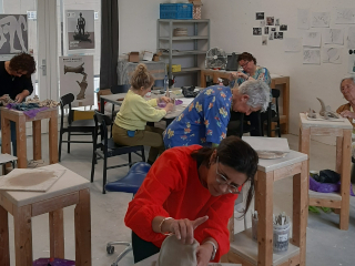 Cursusgroep aan het boetseren in het atelier